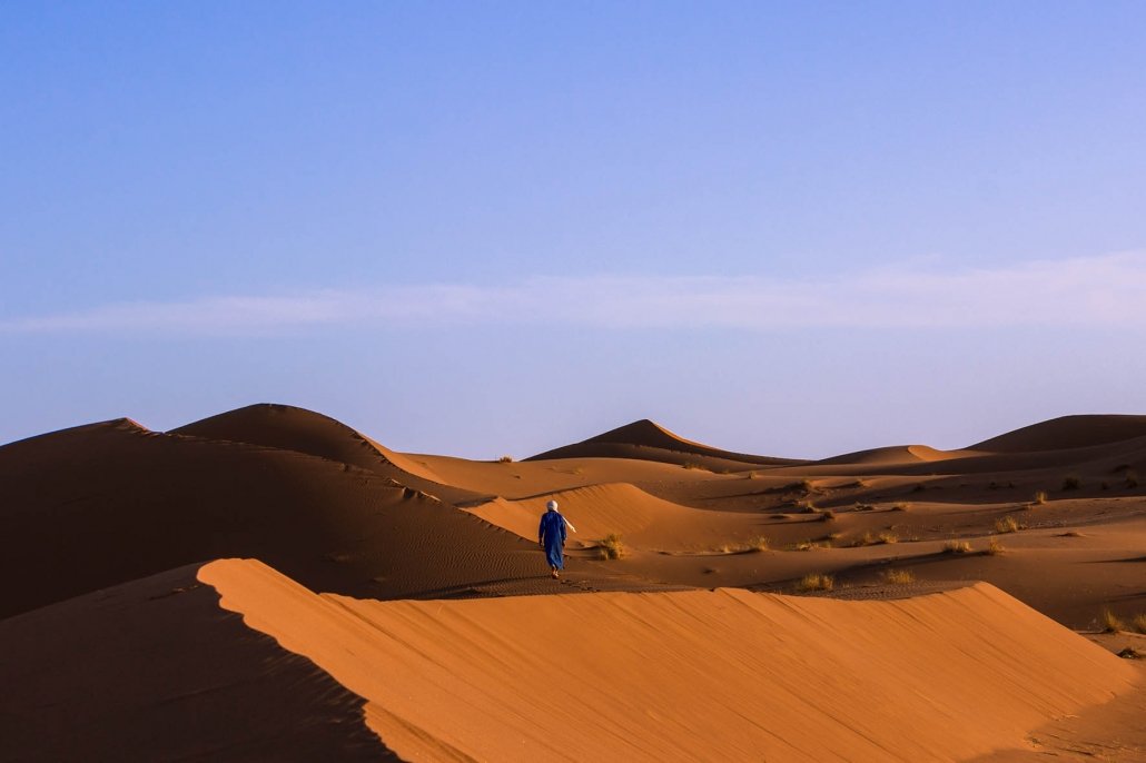 come andare nel deserto del Sahara: berbero cammina sulla duna