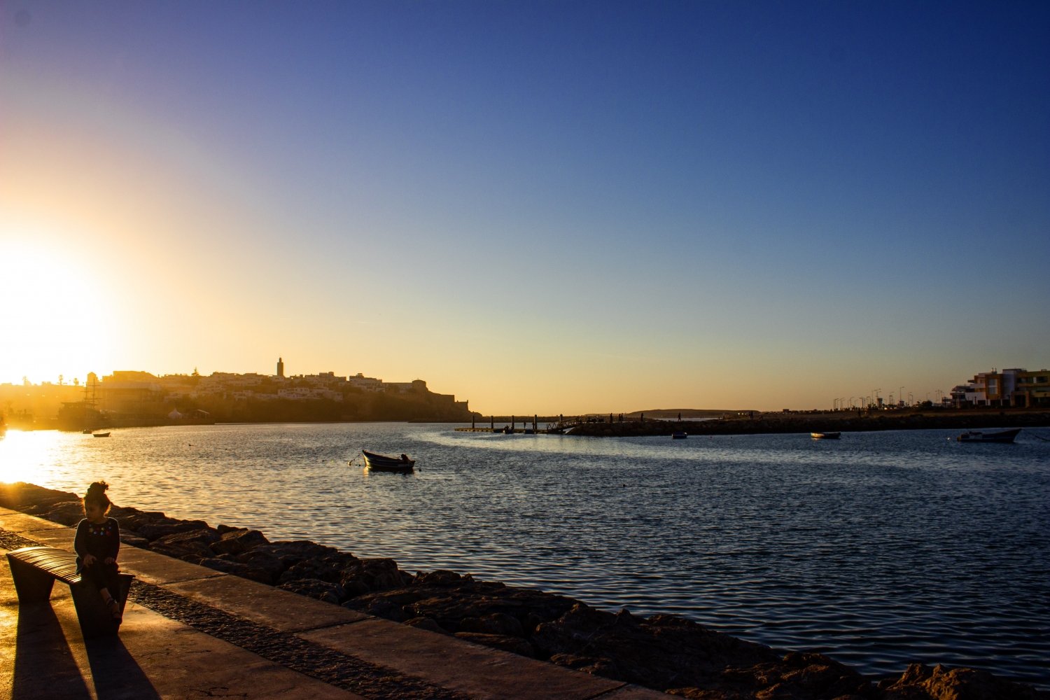 Rabat:bambina seduta su una panchina lungo il fiume