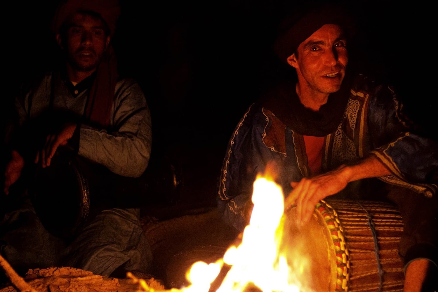 Musica del Marocco: due musicisti suonano nel deserto intorno a un falò