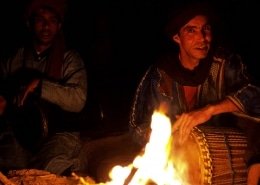 Musica del Marocco: due musicisti suonano nel deserto intorno a un falò